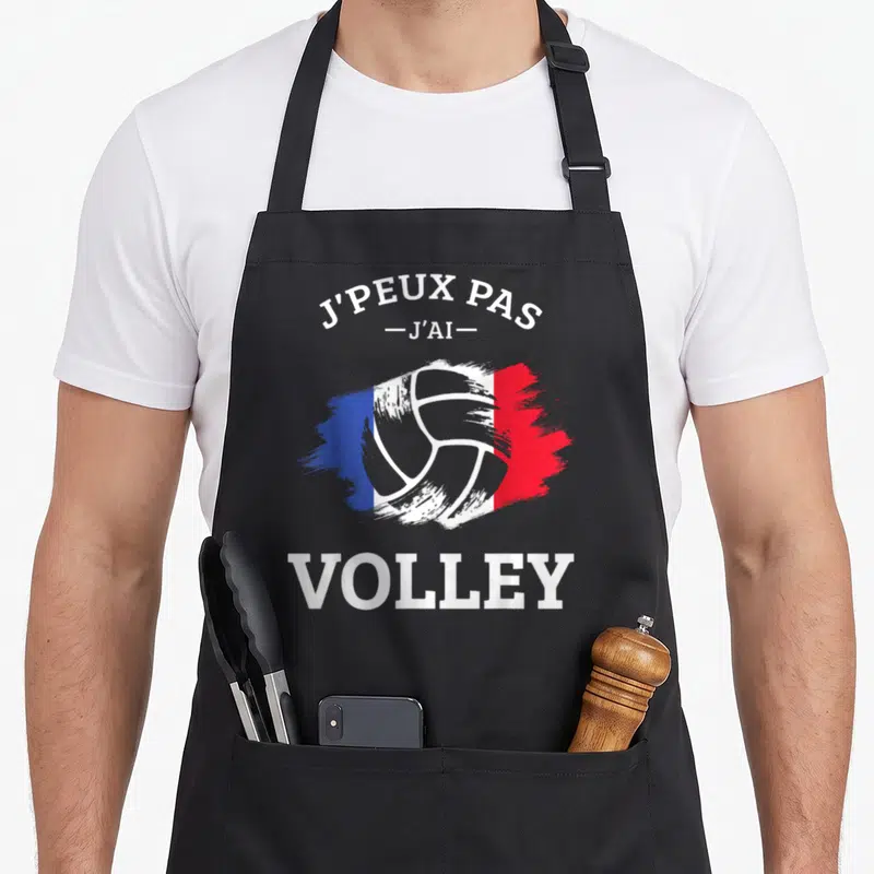 Tablier de cuisine noir avec motif ballon de volley et drapeau français stylisé en touches de peinture.