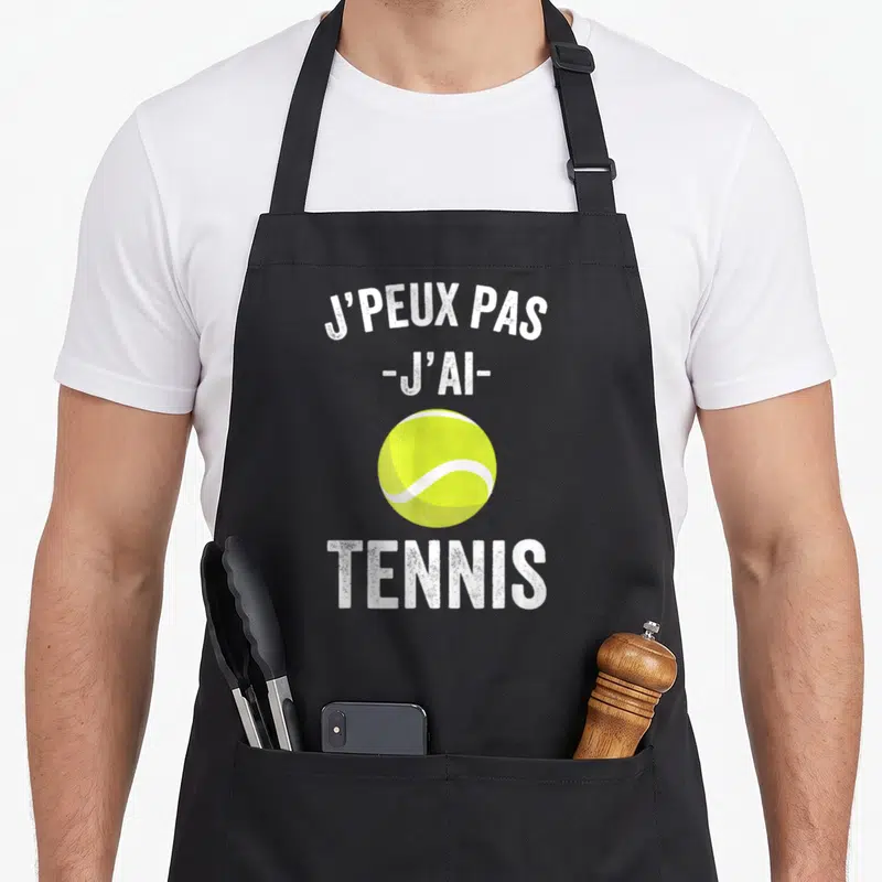 Tablier de cuisine noir avec une balle de tennis jaune et le texte j'peux pas j'ai tennis imprimé en blanc.