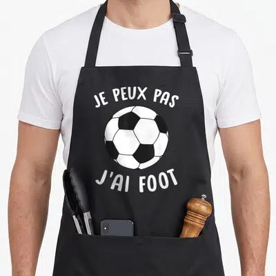 Tablier de cuisine noir avec un ballon de football et le texte je peux pas j'ai foot