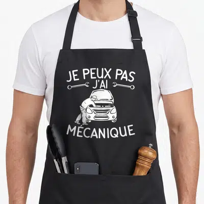 Tablier de cuisine noir avec illustration blanche d'un mécanicien sous capot et texte Je peux pas j'ai mécanique.