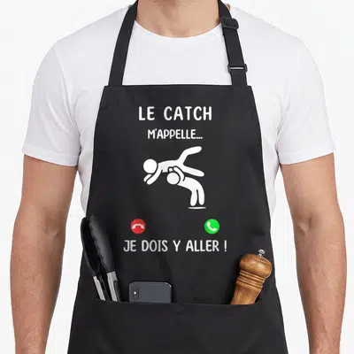 Tablier de cuisine noir avec une illustration blanche de catcheurs et des icônes de téléphone rouge et vert.
