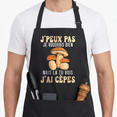 Tablier de cuisine noir avec trois cèpes illustrés et le texte j'peux pas je voudrais bien mais là tu vois j'ai cèpes