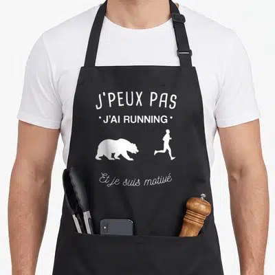 Tablier de cuisine noir avec texte blanc et silhouettes d'un ours et d'un coureur.