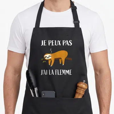 Tablier de cuisine noir avec un fourmi endormi et le texte je peux pas j'ai la flemme en blanc.