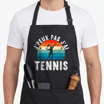 Tablier de cuisine noir avec motif retro tenant un racket et le texte J'peux pas j'ai tennis
