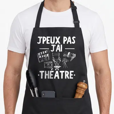 Tablier de cuisine noir avec inscription j'peux pas j'ai théâtre et équipements de filmage dessinés en blanc.