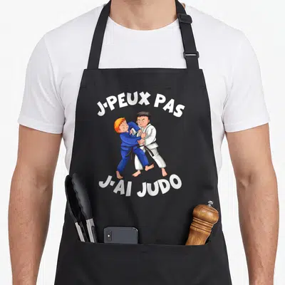 Tablier de cuisine noir avec deux enfants en judo et le texte j-peux pas j-ai judo imprimé en blanc.