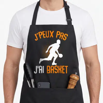 Tablier de cuisine noir avec silhouette blanche d'un basketteur et texte orange J'peux pas j'ai basket.