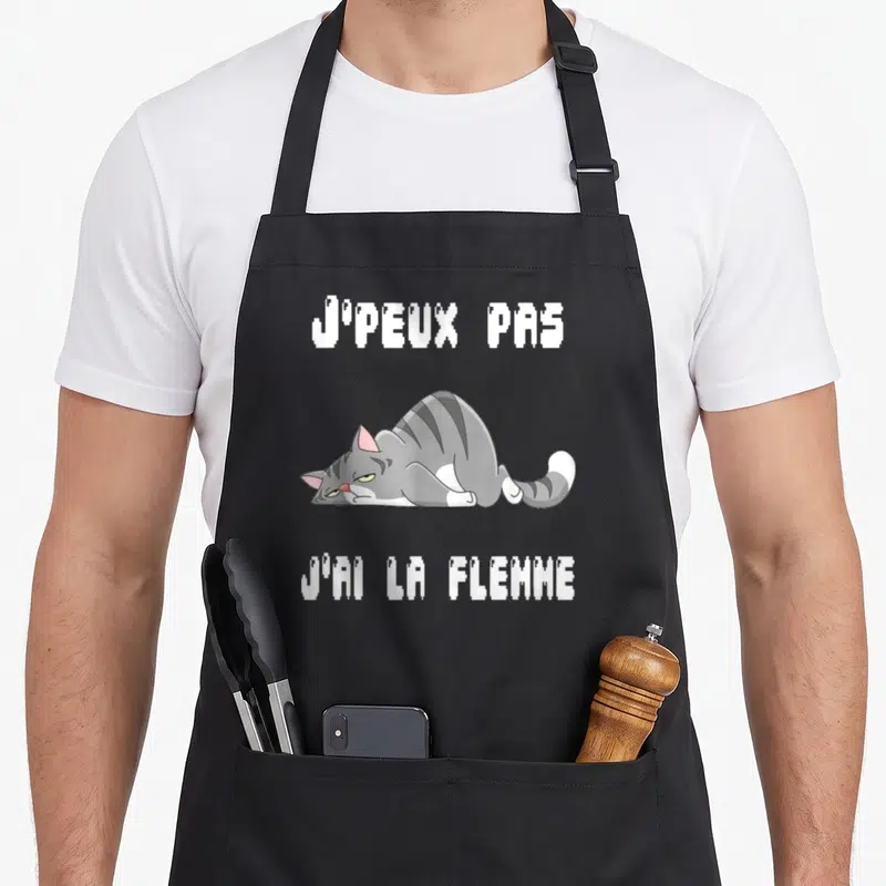 Tablier de cuisine noir avec un chat gris allongé et le texte j'ai la flemme en blanc.