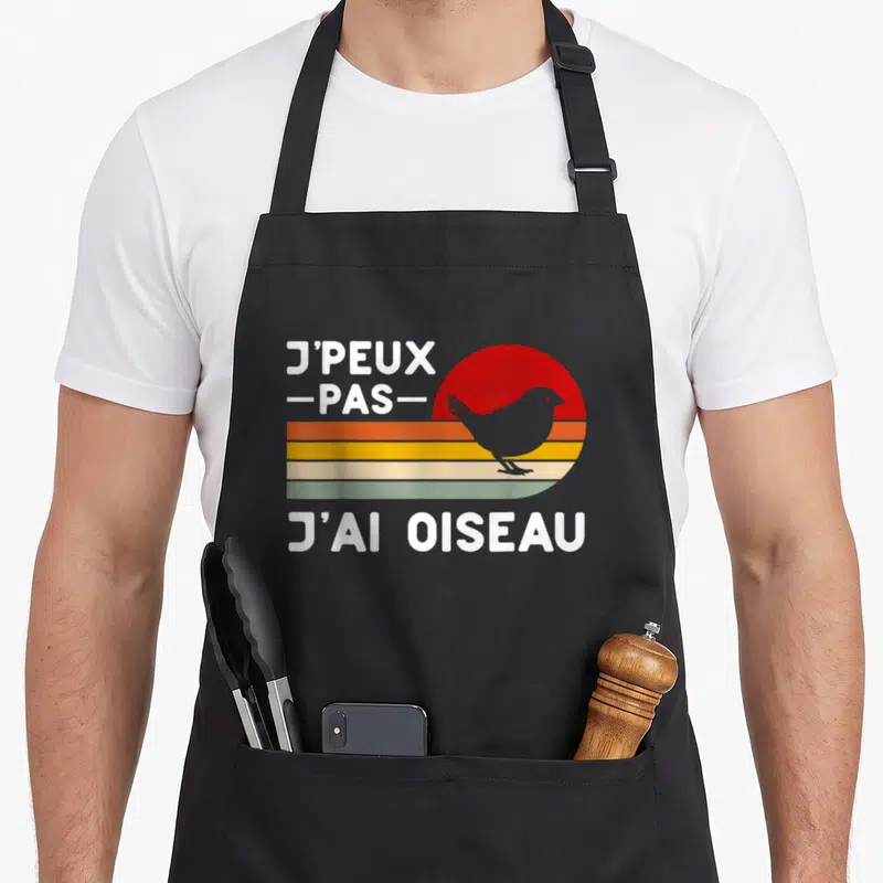 Tablier de cuisine noir avec motif rétro j'ai oiseau et soleil coloré en arrière-plan.