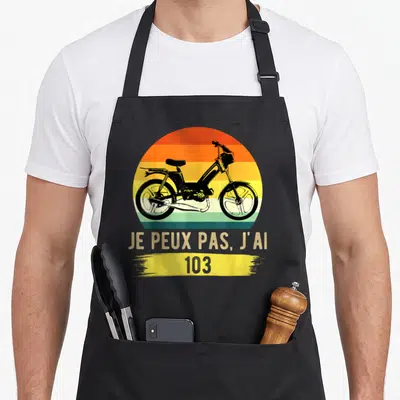 Tablier de cuisine noir avec illustration moto vintage et texte Je peux pas j'ai 103 sur fond coloré circulaire.
