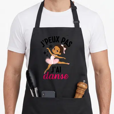 Tablier de cuisine noir avec une illustration de ballerine rose et le texte j'peux pas j'ai danse
