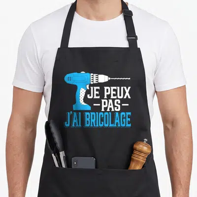 Tablier de cuisine noir avec une perceuse électrique bleue et le texte je peux pas j'ai bricolage en lettres blanches et bleues.