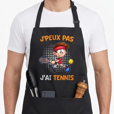 Tablier de cuisine noir avec illustration d'un garçon jouant au tennis et texte j'peux pas j'ai tennis