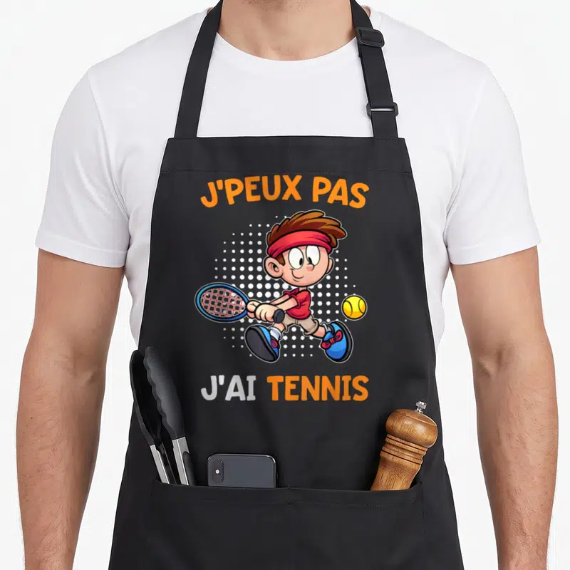 Tablier de cuisine noir avec illustration d'un garçon jouant au tennis et texte j'peux pas j'ai tennis
