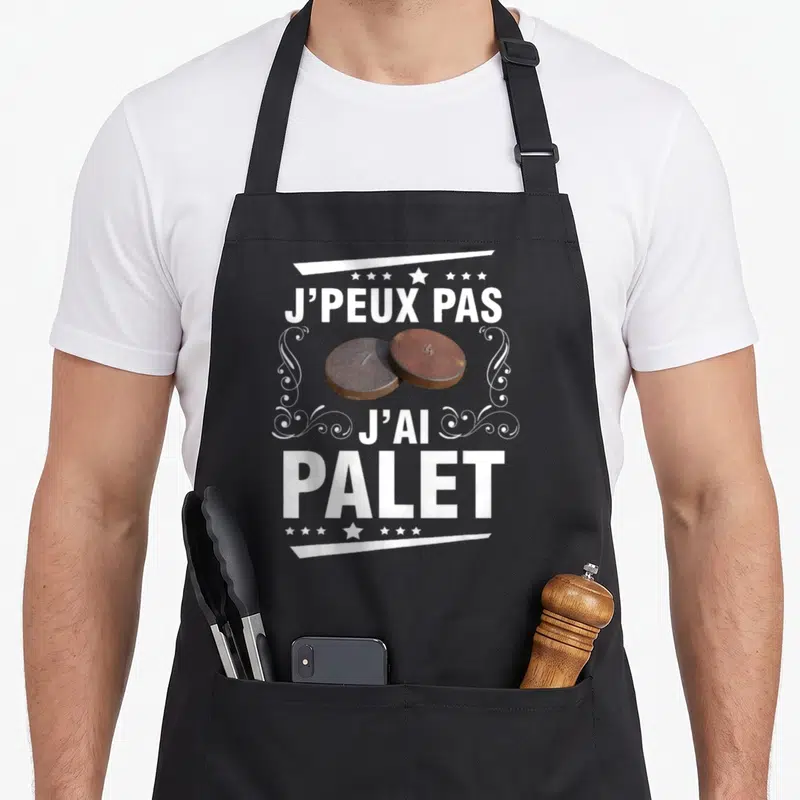 Tablier de cuisine noir avec deux pailles de palet et le texte j'peux pas j'ai palet en blanc.