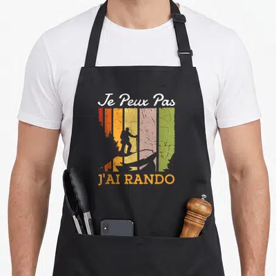 Tablier de cuisine noir avec silhouette de randonneur sur bandes colorées et texte Je Peux Pas J'ai Rando