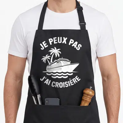Tablier de cuisine noir avec inscription je peux pas j'ai croisière et illustration de navire de croisière entre deux palmiers.