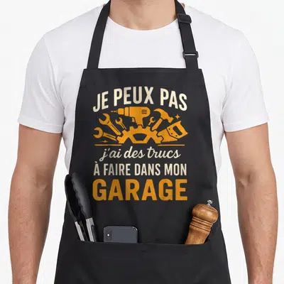 Tablier de cuisine noir avec inscription je peux pas j'ai des trucs à faire dans mon garage et illustrations d'outils orange