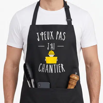 Tablier de cuisine noir avec inscription j'peux pas j'ai chantier et casque de chantier jaune stylisé.