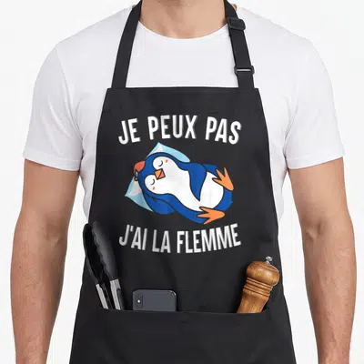 Tablier de cuisine noir avec un pingouin dormant sur une poche de glace et le texte je peux pas j'ai la flemme