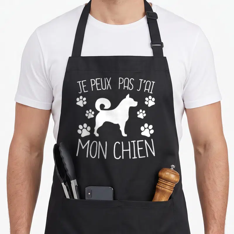 Tablier de cuisine noir avec silhouette de chien blanc, traces de pattes et texte Je peux pas j'ai mon chien.