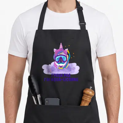 Tablier de cuisine noir avec une licorne en masque de plongée et le texte j'peux pas j'ai aqua-licorne imprimé en violet.