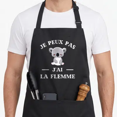 Tablier de cuisine noir avec illustration d'un koala gris et du texte je peux pas j'ai la flemme en blanc.