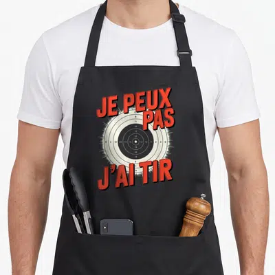 Tablier de cuisine noir avec une cible de tir sportif et le texte je peux pas j'ai tir en lettres rouges.