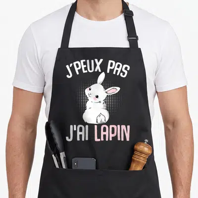 Tablier de cuisine noir avec un lapin blanc mignon et le texte j'ai lapin en lettres blanches et roses.