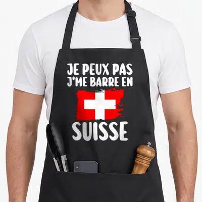 Tablier de cuisine noir avec inscription blanche et drapeau suisse rouge stylisé au pinceau.