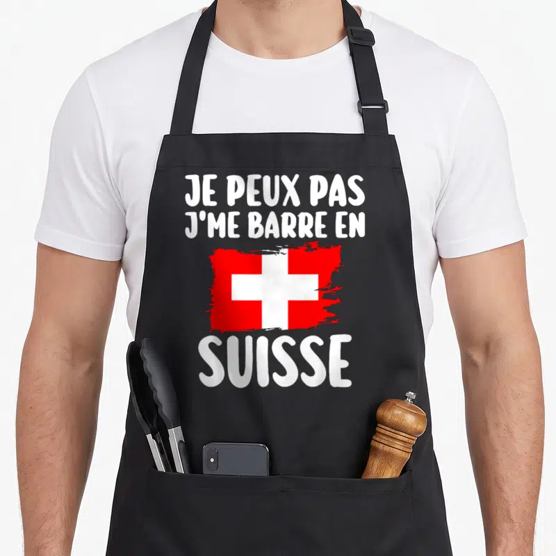 Tablier de cuisine noir avec inscription blanche et drapeau suisse rouge stylisé au pinceau.