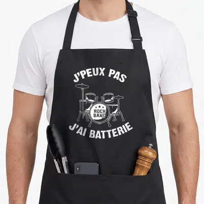 Tablier de cuisine noir avec illustration blanche d'une batterie et le texte J'peux pas j'ai batterie.