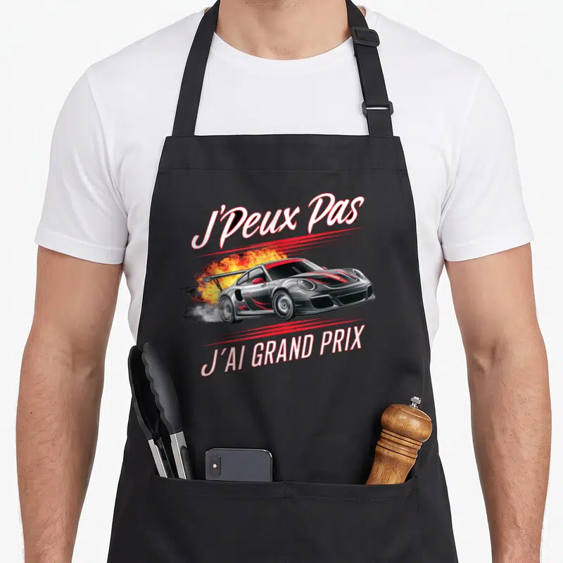 Tablier de cuisine noir avec illustration voiture de course fumante et texte J'Peux Pas J'Ai Grand