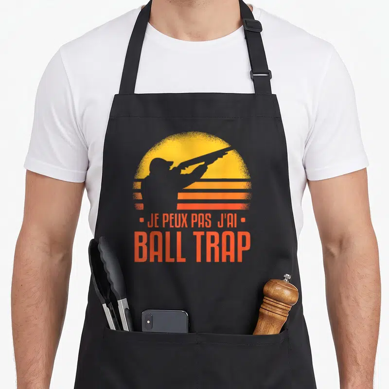 Tablier de cuisine noir avec silhouette de tireur et texte Je peux pas j'ai Ball Trap en orange.