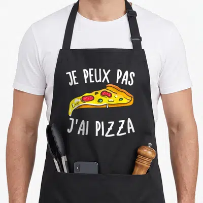 Tablier de cuisine noir avec une part de pizza colorée et le texte je peux pas j'ai pizza en lettres blanches.