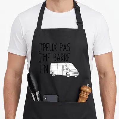 Tablier de cuisine noir avec l'inscription j'peux pas j'me barre en et un dessin de fourgon aménagé blanc.