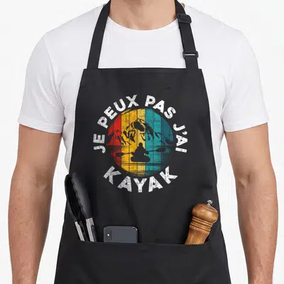Tablier de cuisine noir avec motif circulaire vintage représentant un kayaker et le texte je peux pas j'ai kayak en blanc.