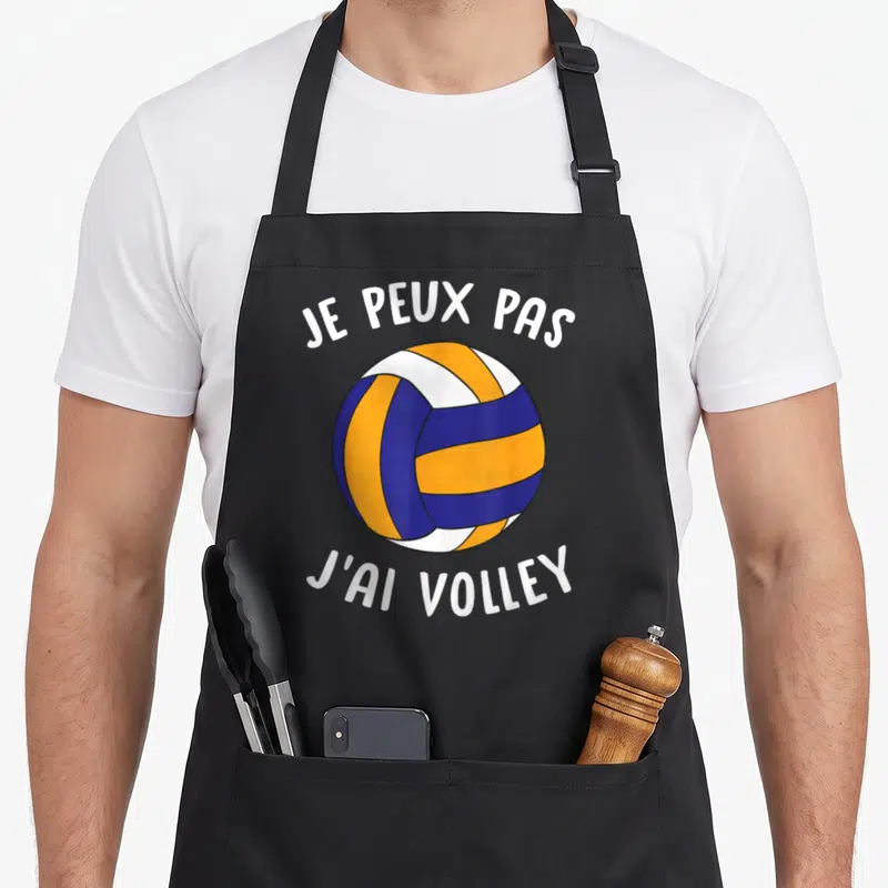 Tablier de cuisine noir avec une balle de volley orange et bleue et le texte je peux pas j'ai volley.