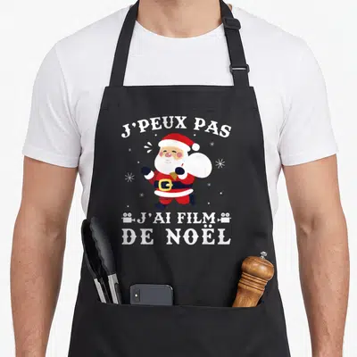 Tablier de cuisine noir avec illustration d'un Père Noël courant portant un sac blanc et des caméras.
