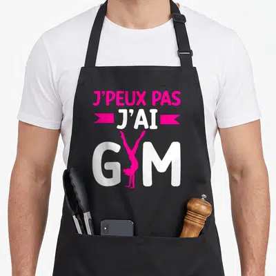 Tablier de cuisine noir avec inscription j'ai Gym et silhouette rose d'une gymnaste en appui main.
