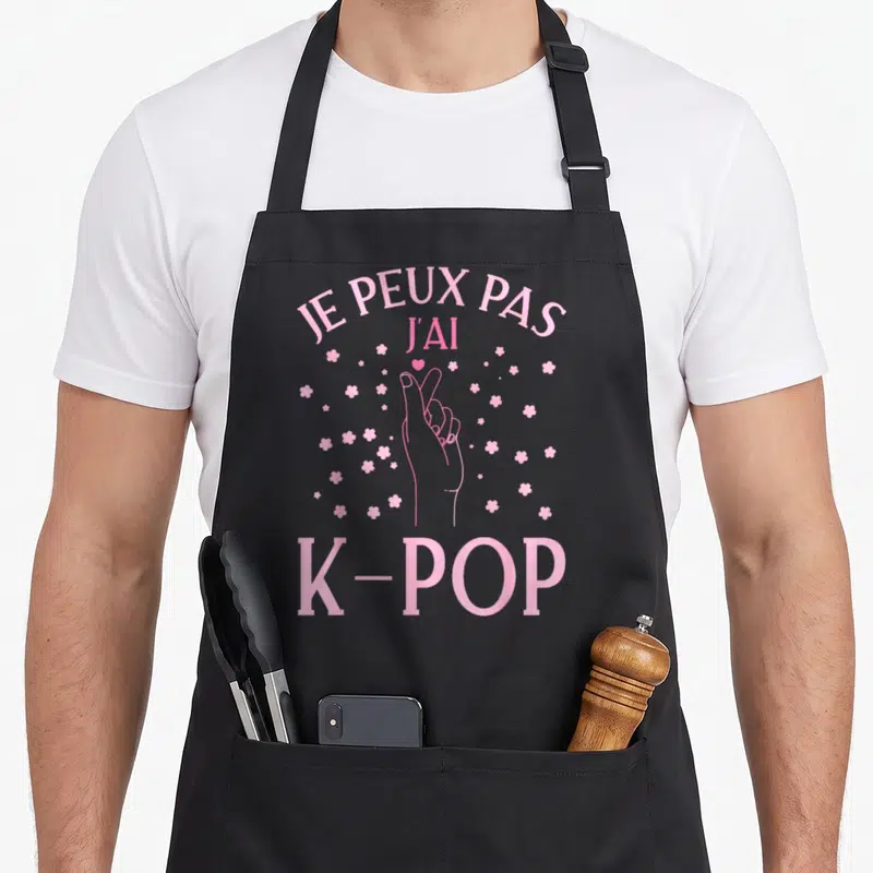 Tablier de cuisine noir avec inscription rose Je peux pas j'ai K-Pop et main formant un cœur entourée de fleurs.