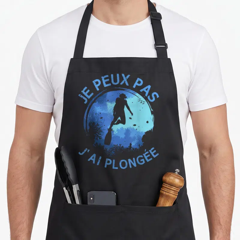 Tablier de cuisine noir avec silhouette de plongeur et texte je peux pas j'ai plongée en bleu sur fond circulaire sous-marin
