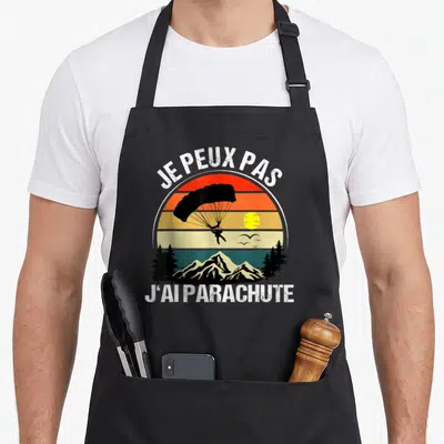 Tablier de cuisine noir avec illustration vintage d'un parachutiste au-dessus de montagnes et texte Je peux pas j'ai parachute