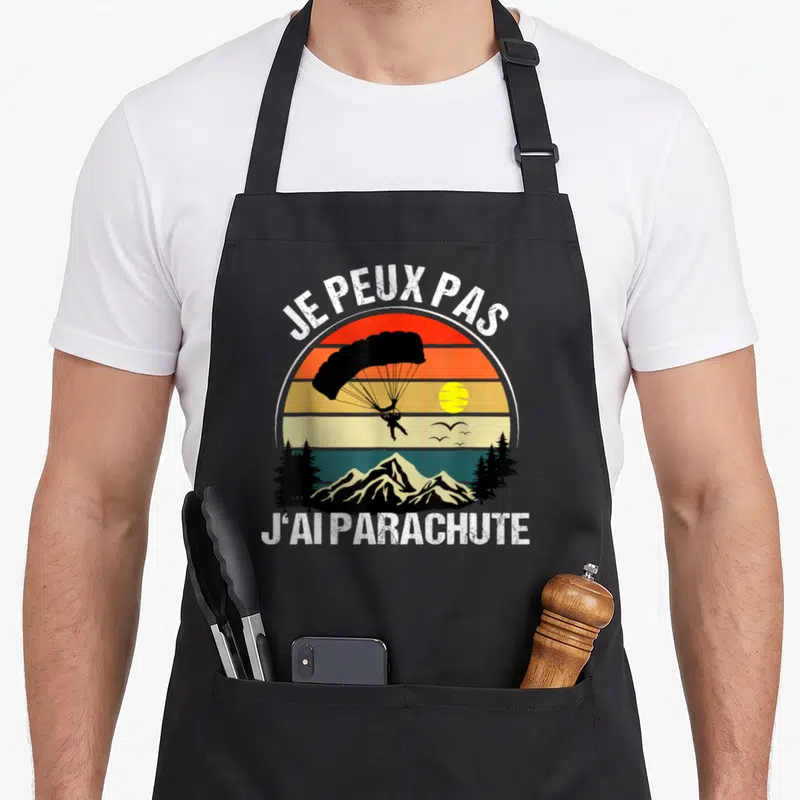 Tablier de cuisine noir avec illustration vintage d'un parachutiste au-dessus de montagnes et texte Je peux pas j'ai parachute
