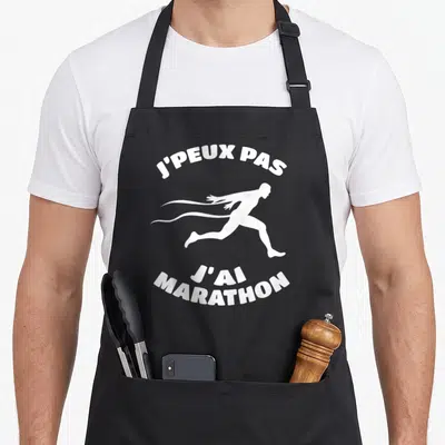 Tablier de cuisine noir avec silhouette de coureur blanc et texte j'peux pas j'ai marathon imprimé en haut et en bas.