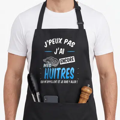 Tablier de cuisine noir avec inscription j'peux pas j'ai encore mes huîtres et dessin d'huître bleue.