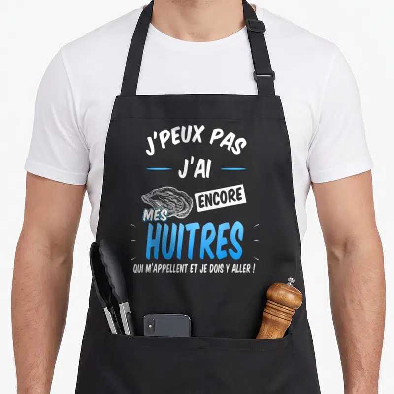 Tablier de cuisine noir avec inscription j'peux pas j'ai encore mes huîtres et dessin d'huître bleue.