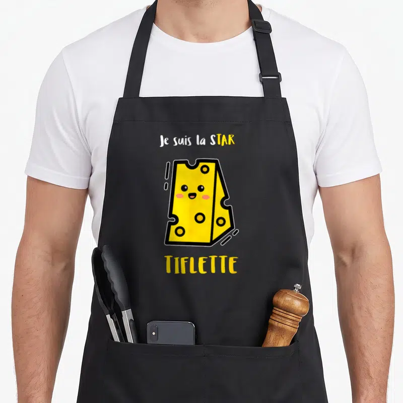 Tablier de cuisine noir avec une illustration de tartiflette jaune souriante et le texte je suis la star tifleette
