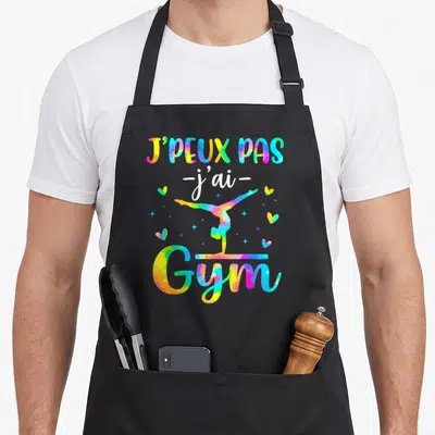 Tablier de cuisine noir avec silhouette de gymnaste colorée et texte J'peux pas j'ai Gym en lettres arc-en-ciel.